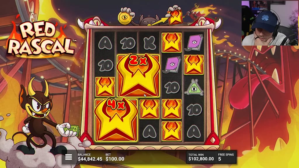 Gameplay during Red Rascal's IGNITE THE NIGHT Hidden Epic Bonus showing Colossal Wild symbols with 2x and 4x multipliers, the Pendulum in Wild Mode above the grid, and a total win of $102,800.00 with 5 free spins remaining