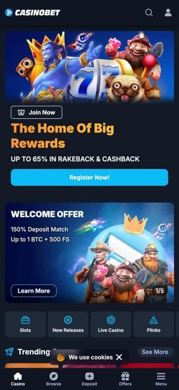 CasinoBet mobile app homepage showing welcome offers including 150% deposit match up to 1 BTC plus 500 free spins, rakeback and cashback rewards up to 65%, with colorful gaming characters and navigation menu